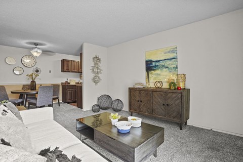 A living room with a grey couch and a wooden cabinet.