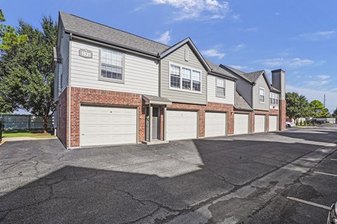 A row of houses with garages and driveways.