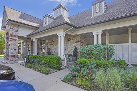 A house with a stone pillar and a car parked in front.