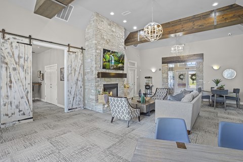 A living room with a stone fireplace and a television mounted above it.