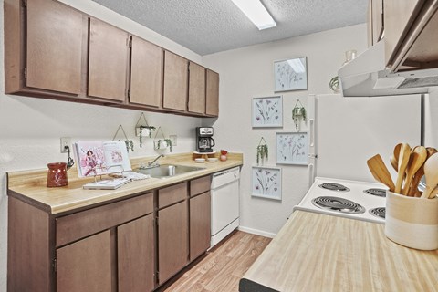 A kitchen with brown cabinets and a white refrigerator.