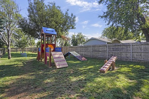 A playground with a slide and a wooden structure.
