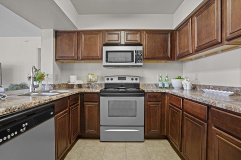 A kitchen with a black dishwasher and a silver oven.