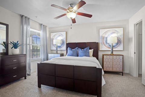 A bedroom with a large bed and a ceiling fan.