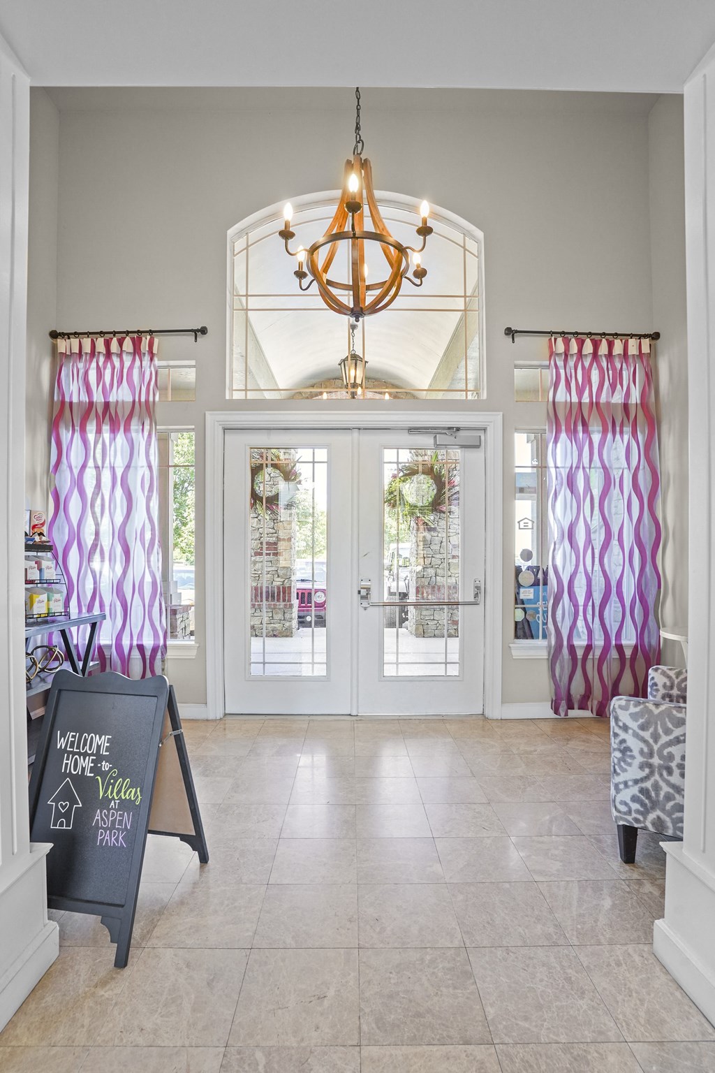 A chalkboard sign that says "Welcome Home" is in front of a glass door.