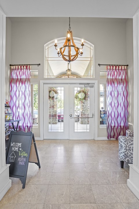 A chalkboard sign that says "Welcome Home" is in front of a glass door.