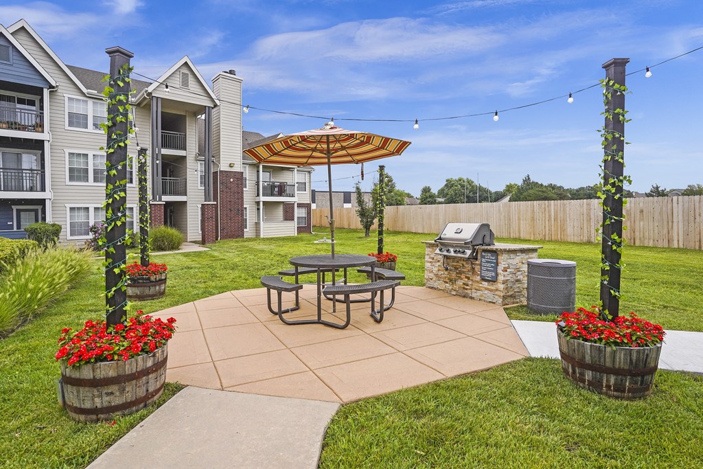A patio with a table and chairs and a bench with flower pots on it.