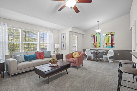 A living room with a grey couch, a red chair, and a brown coffee table.