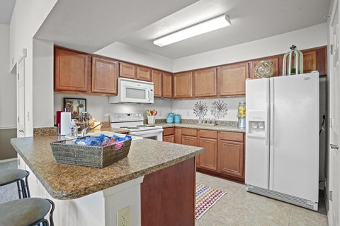 A kitchen with brown cabinets and a white refrigerator.
