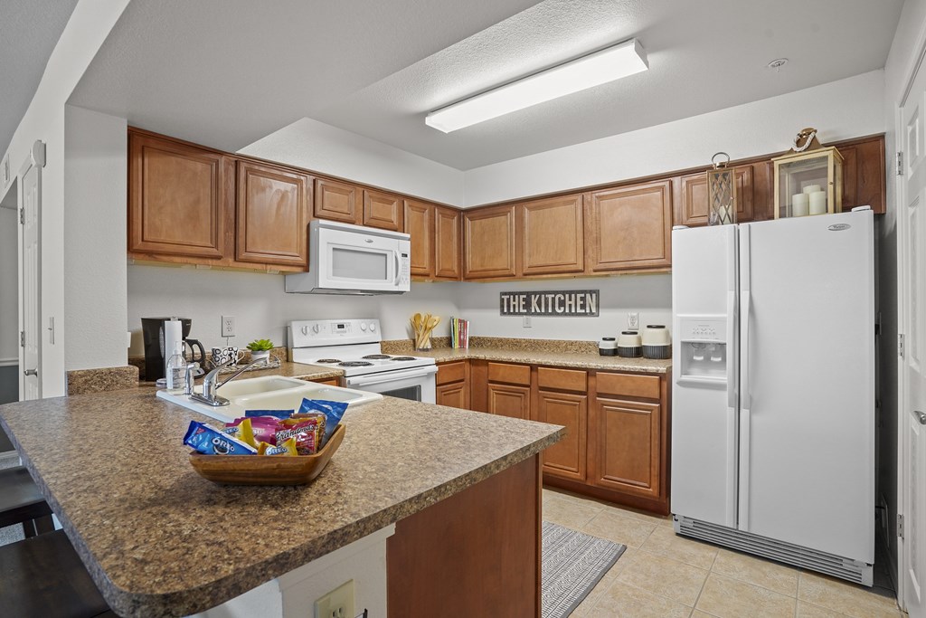 A kitchen with brown cabinets and a white refrigerator.