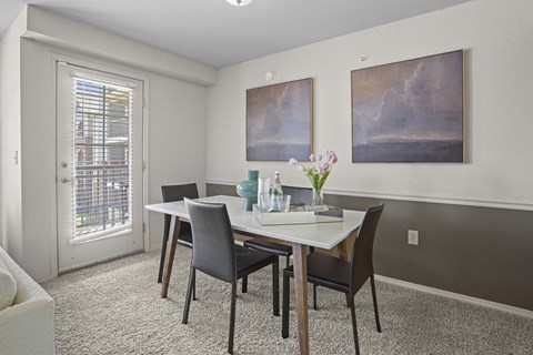 A dining room with a table and chairs.