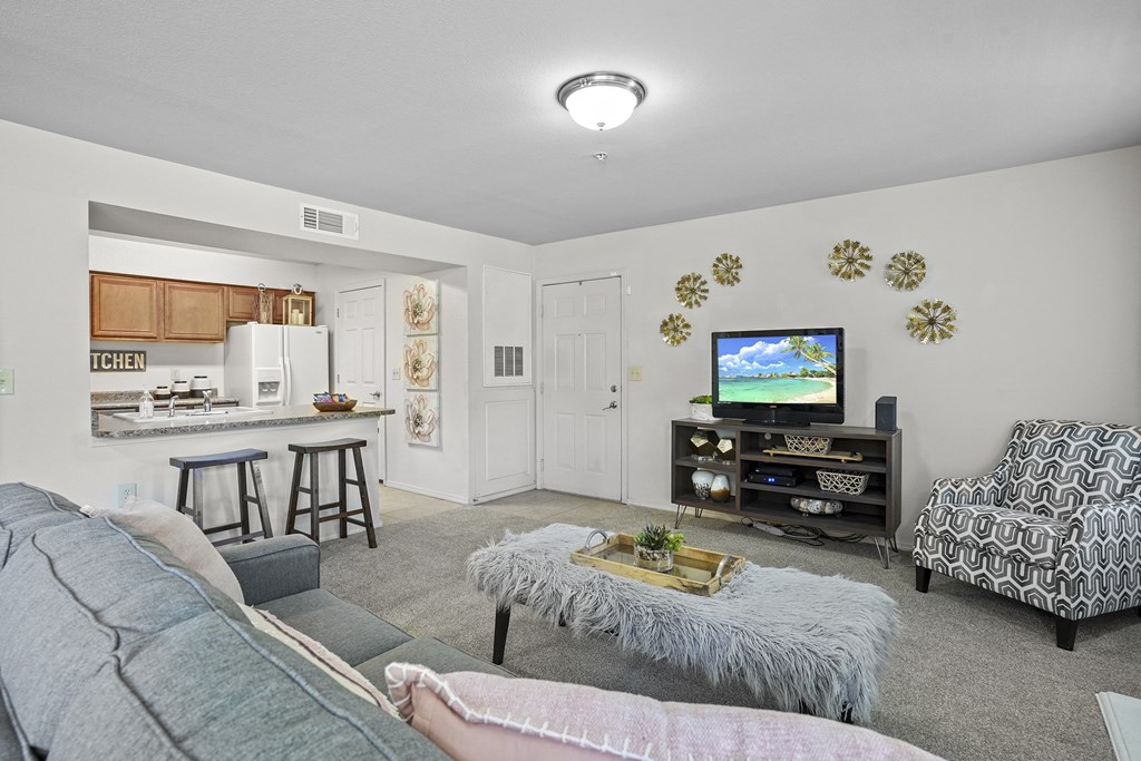 A living room with a grey couch and a white chair.