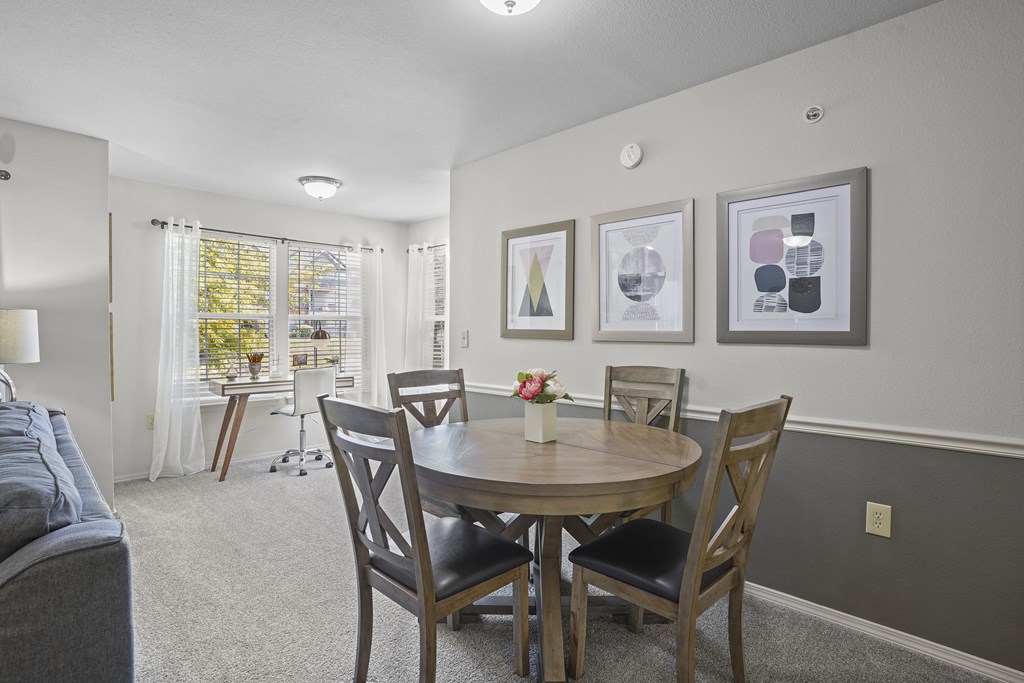 A dining room with a table and chairs.