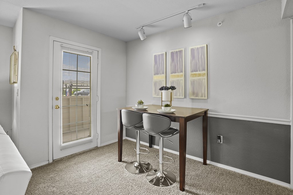 A dining room with a table and chairs.