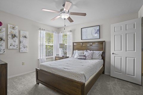 A bedroom with a large bed and a ceiling fan.