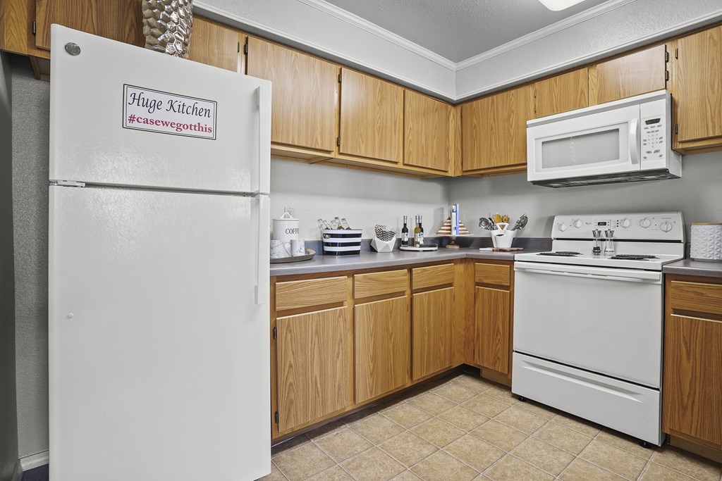A kitchen with wooden cabinets and white appliances.