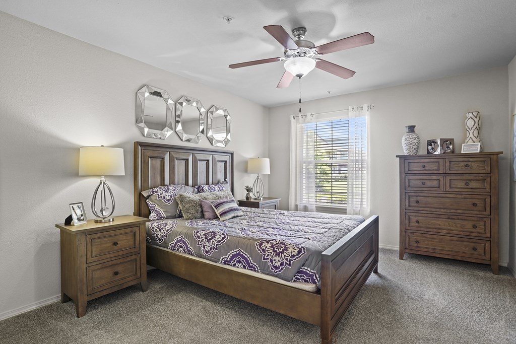 A bedroom with a bed, nightstand, and dresser.