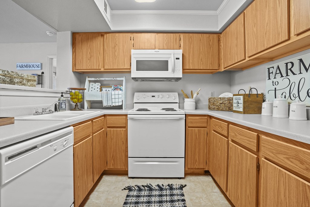 A kitchen with wooden cabinets and a white dishwasher.