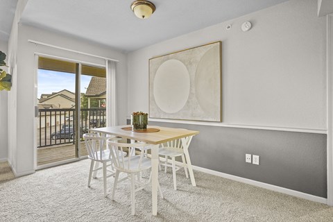 A dining room with a table and chairs.