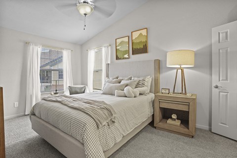 A bedroom with a large bed and a ceiling fan.