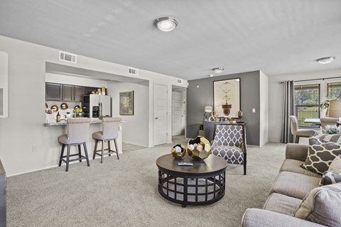 A living room with a grey couch and a black coffee table.
