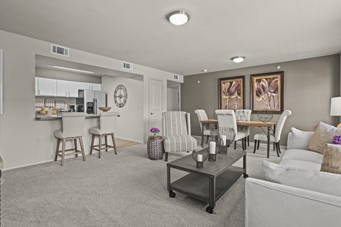 A living room with a grey carpet and white furniture.