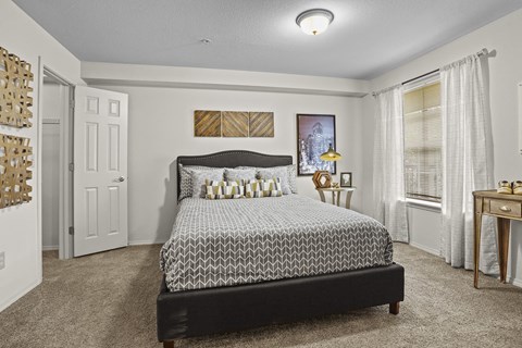 A bedroom with a large bed and a painting on the wall.