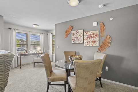 A dining room with a table set for two and a view of the street outside.