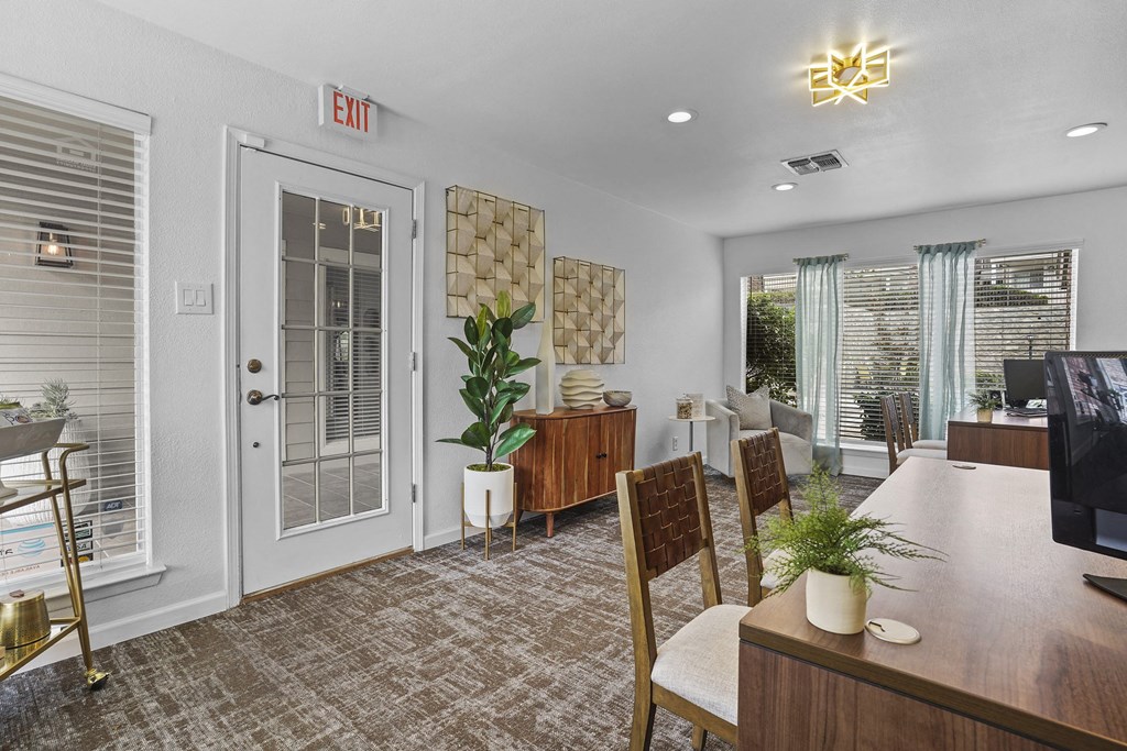 A room with a brown carpet and a wooden table with a plant on it.