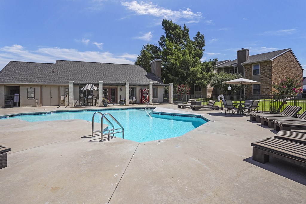 A swimming pool with a slide and a building in the background.