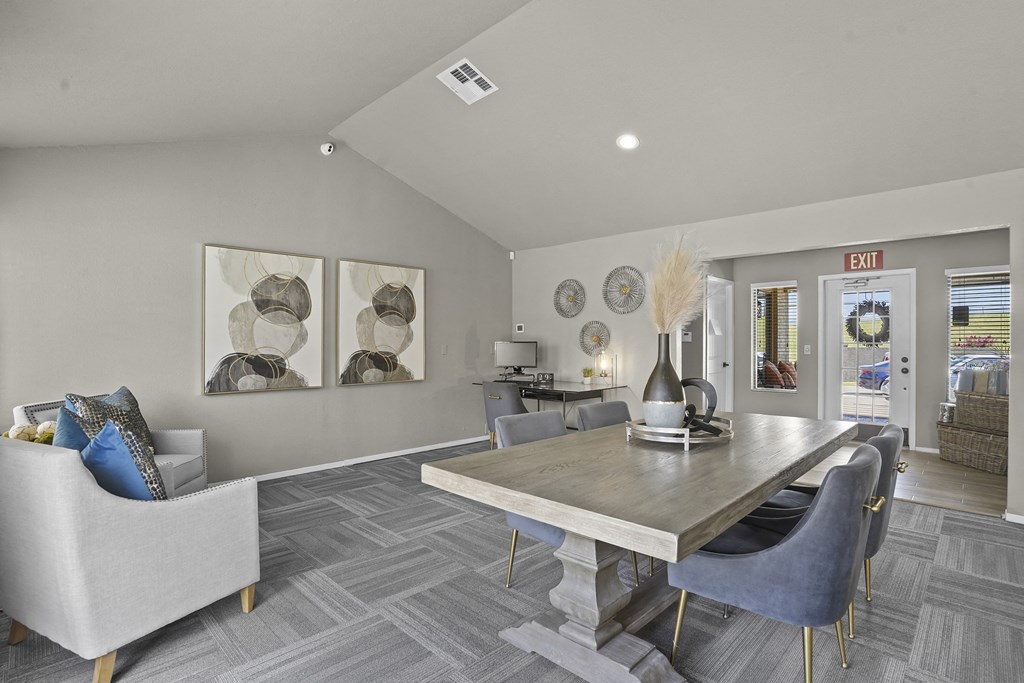 A grey and white living room with a grey sofa and a grey dining table.