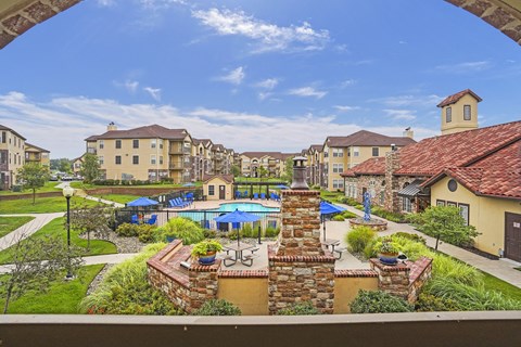 A view of a residential area with a pool and a stone wall.