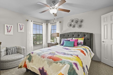 A bedroom with a large bed and a ceiling fan.
