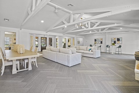 A spacious living room with a grey carpet and white furniture.