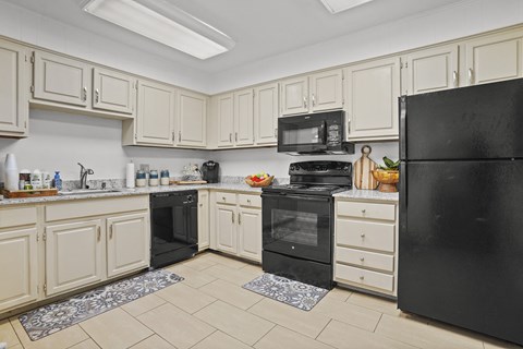 A kitchen with black appliances and white cabinets.