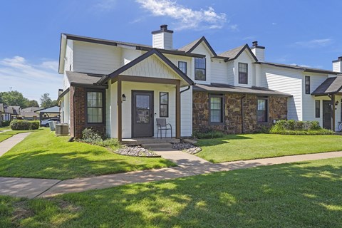 A white house with a brown door and windows.