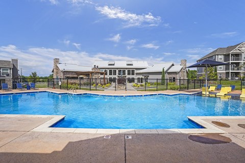 A large outdoor swimming pool with a building in the background.