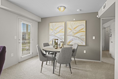A dining room with a table and chairs.