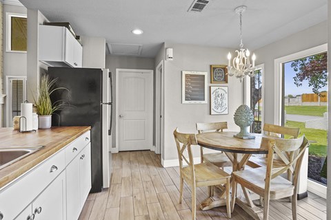 A kitchen with a table and chairs in the middle of the room.
