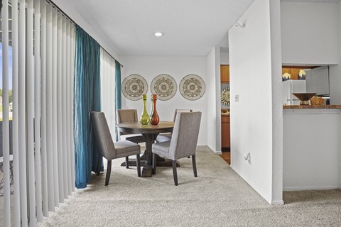 A dining room with a table and chairs.