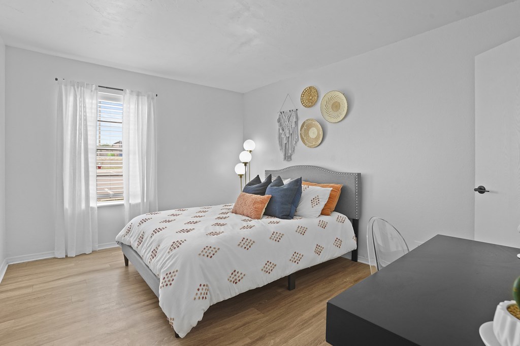 A bedroom with a bed, a chair, and a table.