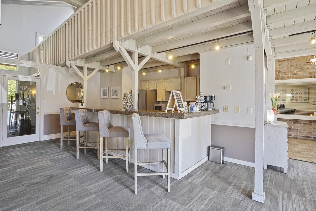 A bar area with white chairs and a counter.