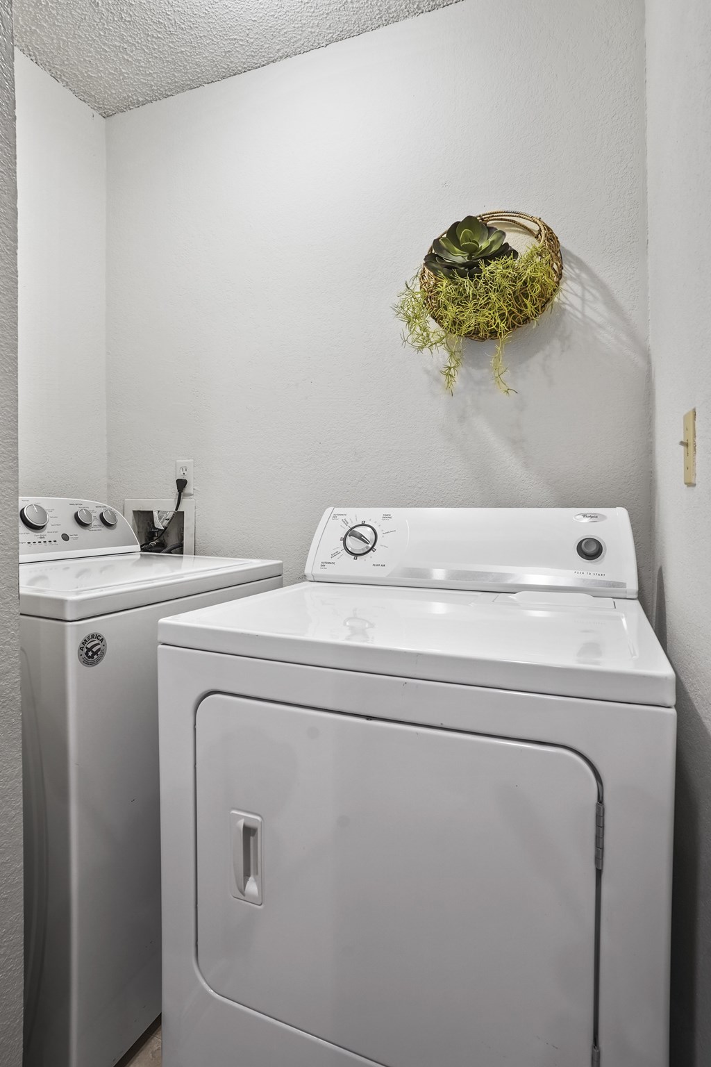 A white washing machine and sink in a laundry room.