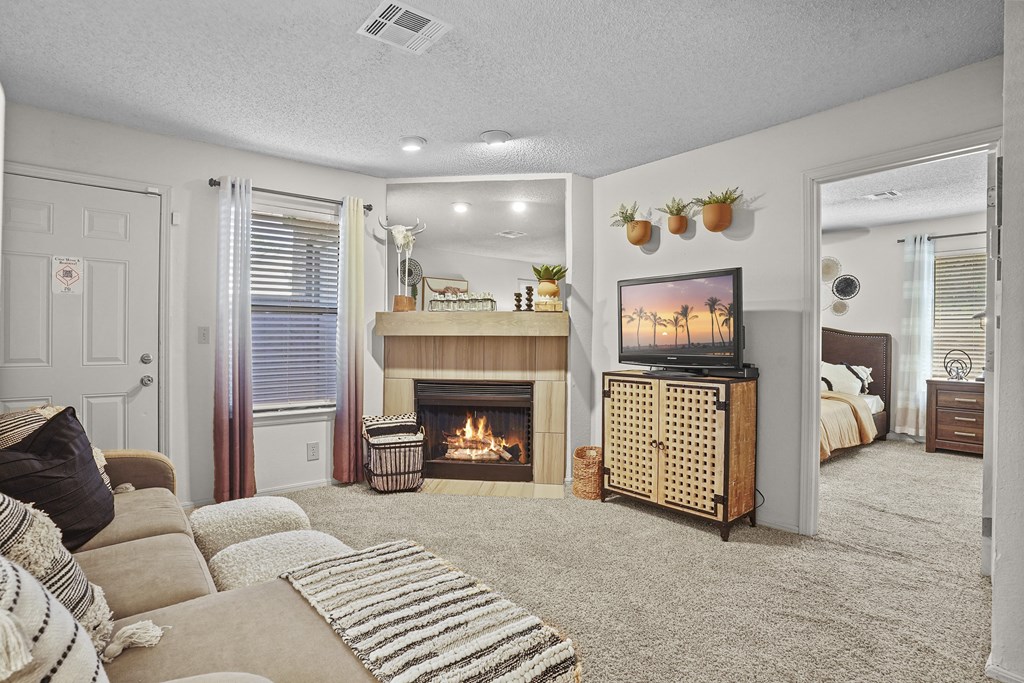 A cozy living room with a fireplace and a television.
