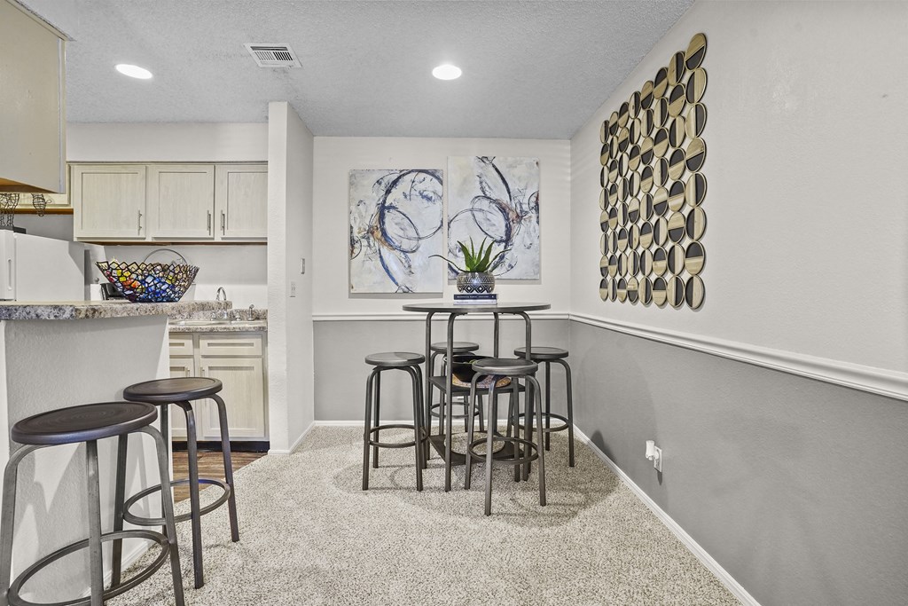 A kitchen with a bar area and a painting on the wall.