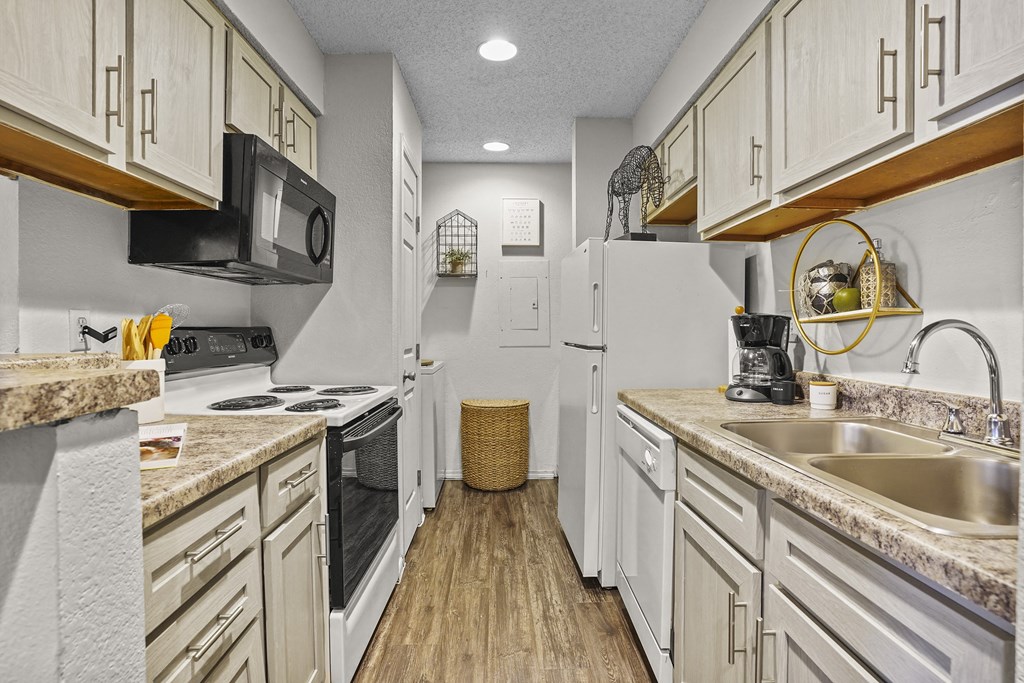 A kitchen with white appliances and wooden cabinets.