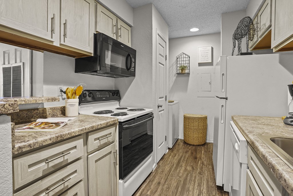 A kitchen with white cabinets and appliances.