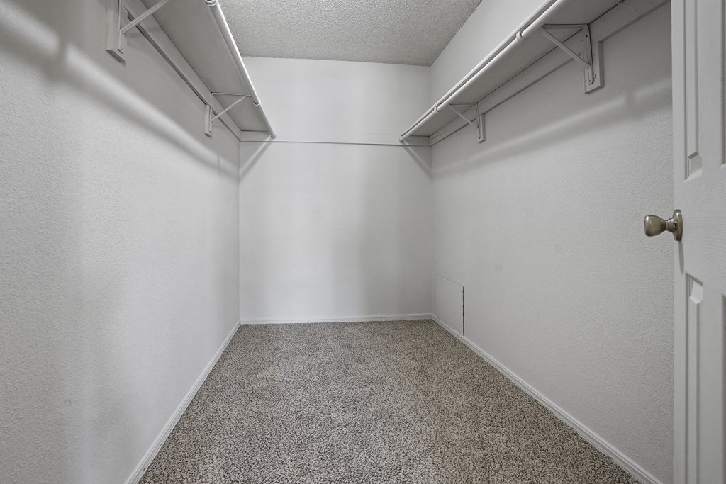 A white room with a carpeted floor and a door on the right.