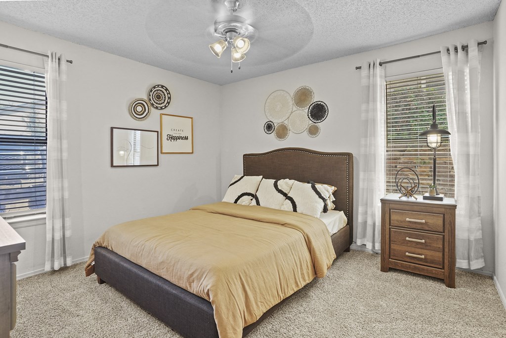 A bedroom with a bed, nightstand, and decorative wall art.