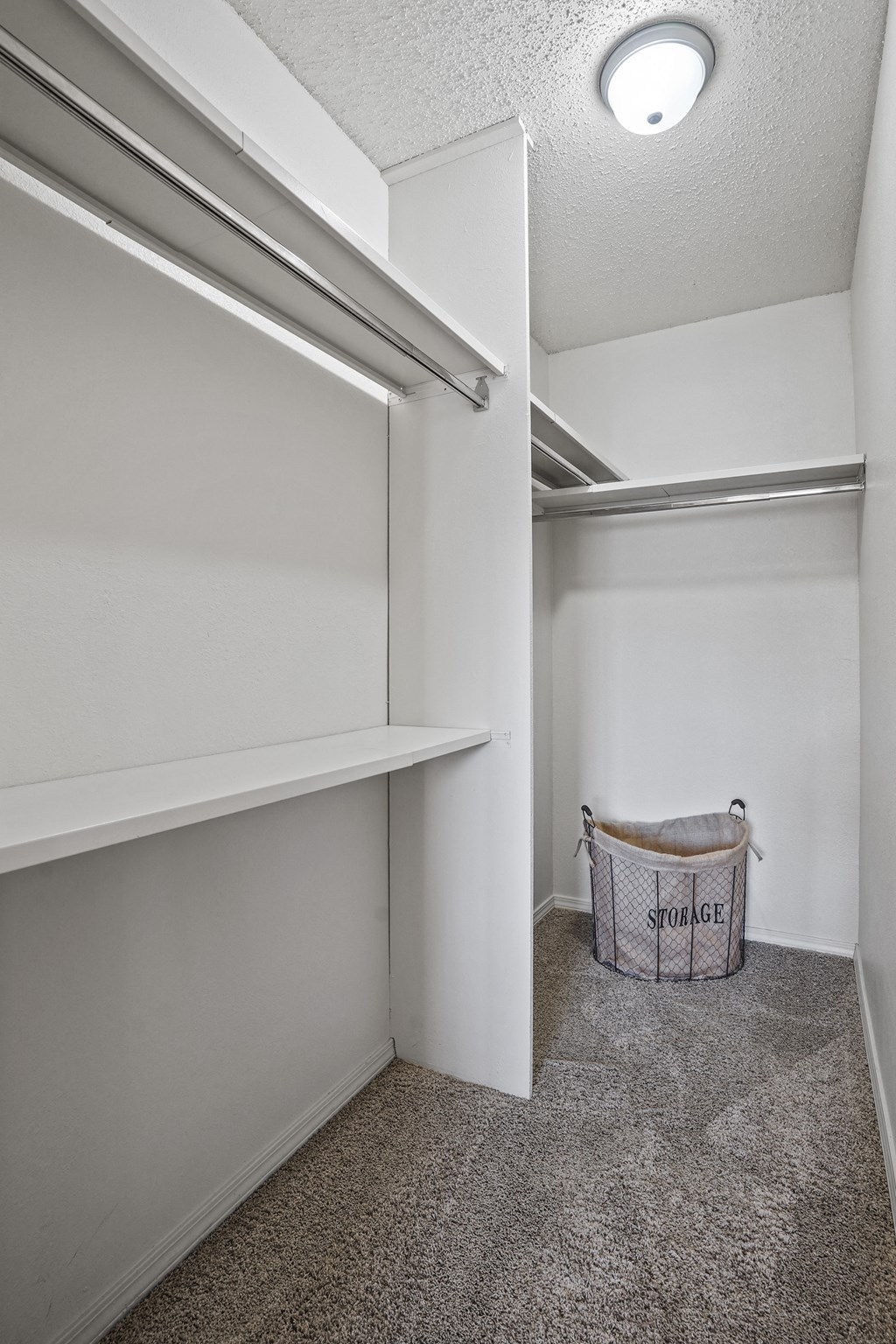A storage bin sits in the corner of a white room.